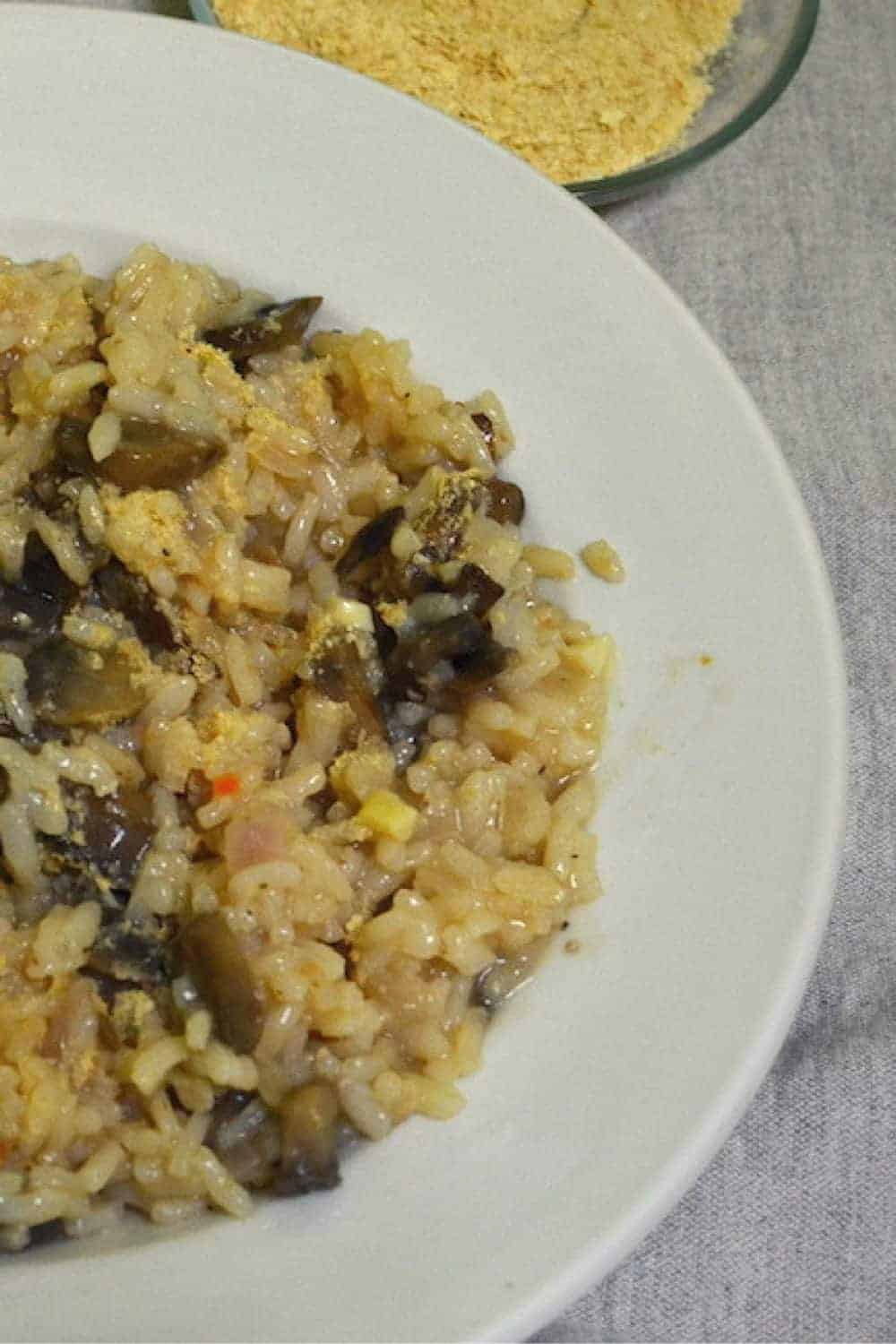 Mushroom Risotto in a white plate topped with nutritional yeast - - Vegan Easter Recipes