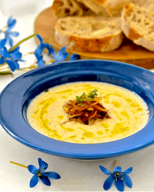 Blue bowl with yellow soup and grilled onions