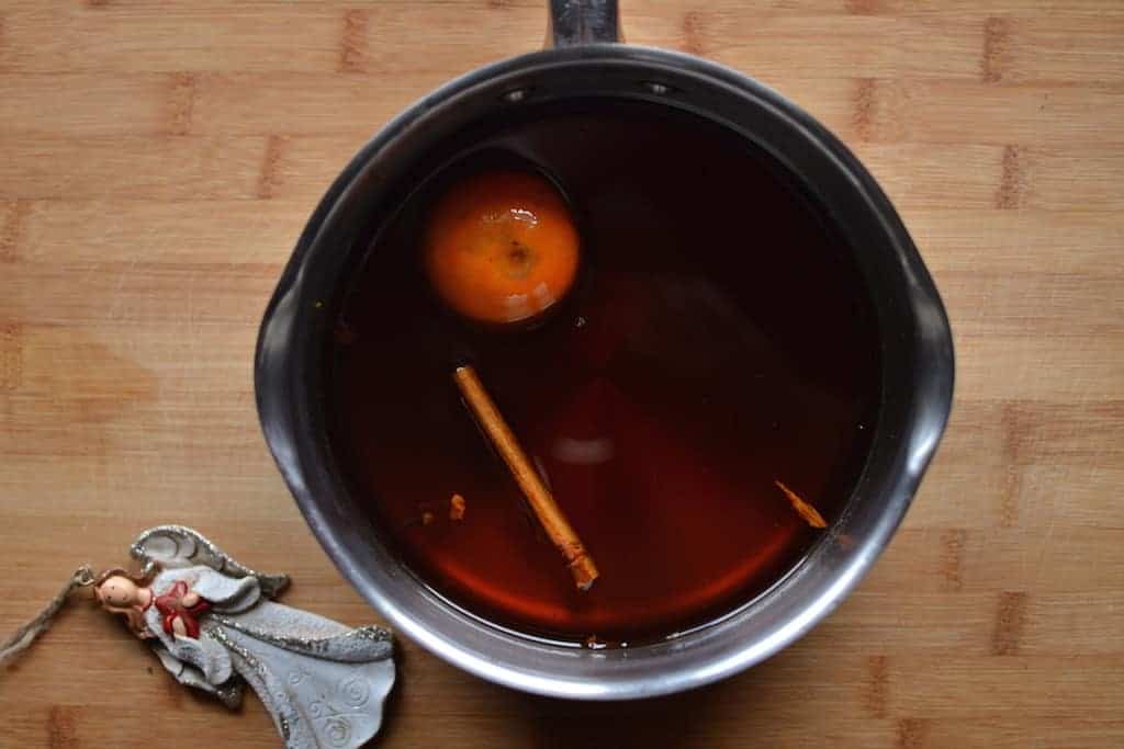 Syrup with an orange and cinnamon in a pan