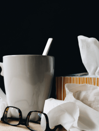a cup with tea, tissues and blsck glasses, allergic rhinitis