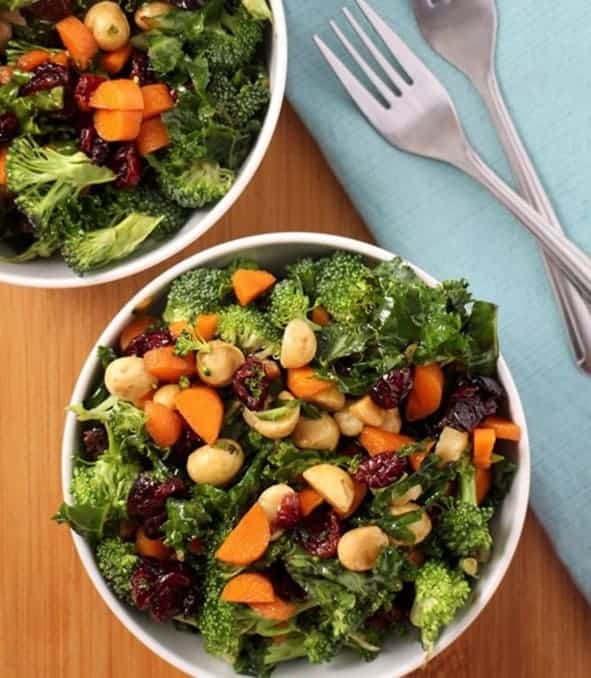 2 bowls of Kale salad with 2 forks in a blue liner - - Vegan Easter Recipes