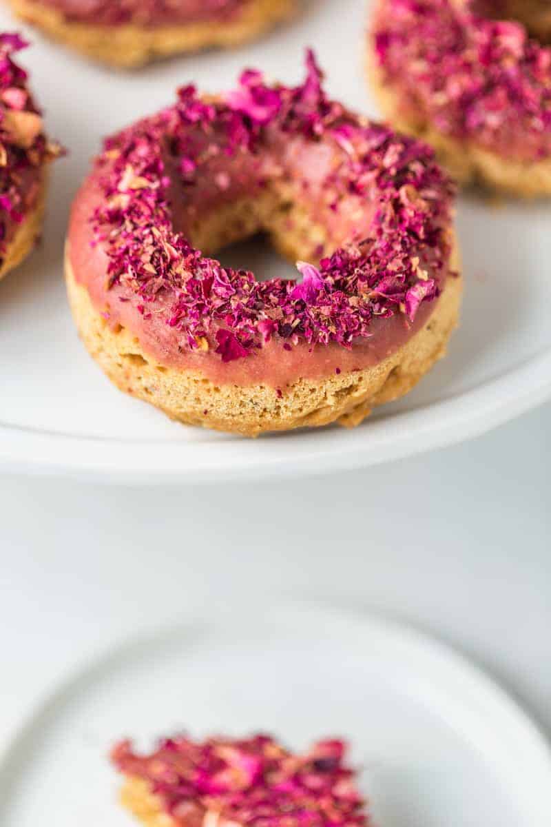 1 piece of LEMON CHIA DONUT WITH ROSE FROSTING in a white plate
