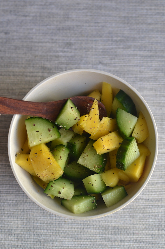 ccumber avocado sala in a white bowl with a wooden spoon. 