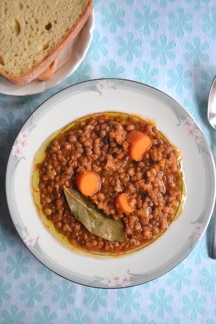 lentil soup in white plate in a blue cloth table