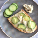 a slice of bread with cucumber and cream cheese
