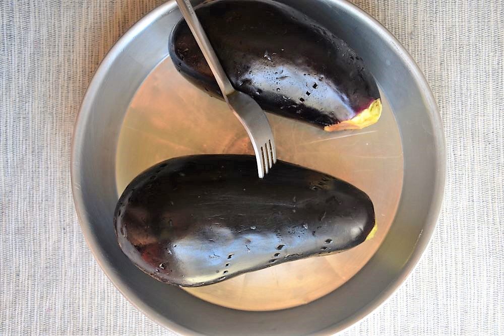 eggplants with a fork in a pan