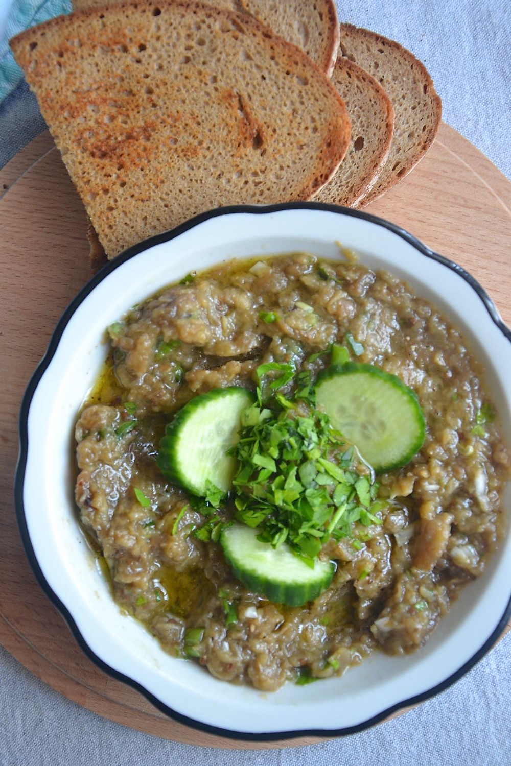 Melirzanosalate with baked bread in a wooden board